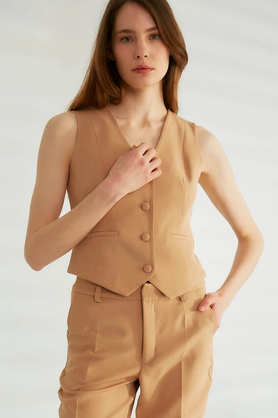 A model wears ROB10384 - Vest - Camel, wholesale Vest of Robin to display at Lonca