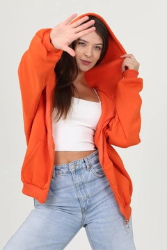 Bir model, Mode Roy toptan giyim markasının 35100 - Sweatshirt - Orange toptan Hoodie ürününü sergiliyor.