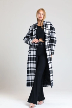 Bir model, SENSE toptan giyim markasının sns10878-plaid-lined-cashmere-long-coat-black-&-white toptan Kaban ürününü sergiliyor.