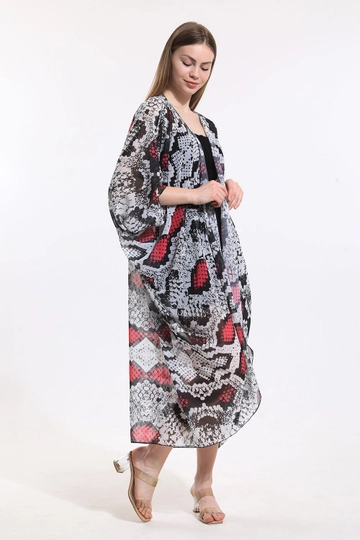 Bir model, SENSE toptan giyim markasının  Sense Ekru Fuşya Yılan Desen Şifon Plaj Kimono
 toptan Kimono ürününü sergiliyor.