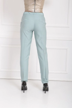 Bir model, SENSE toptan giyim markasının sns10056-mint-waist-bridged-ornamental-stitched-trousers toptan Pantolon ürününü sergiliyor.