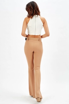 Bir model, SENSE toptan giyim markasının sns10141-beige-flared-belted-knitted-fabric-trousers-pnt32439 toptan Pantolon ürününü sergiliyor.
