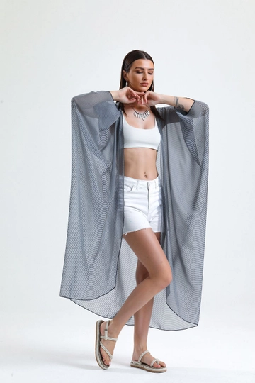 Bir model, SENSE toptan giyim markasının  Sense Laci İnce Çizgili Şifon Plaj Kimono
 toptan Kimono ürününü sergiliyor.