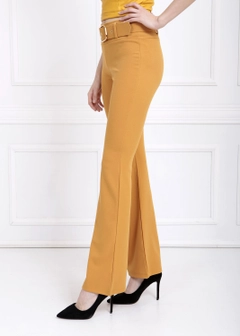 Bir model, SENSE toptan giyim markasının sns10628-sense-mustard-flare-leg-belted-knitted-fabric-trousers-pnt32439 toptan Pantolon ürününü sergiliyor.