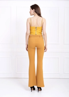 Una modella di abbigliamento all'ingrosso indossa sns10628-sense-mustard-flare-leg-belted-knitted-fabric-trousers-pnt32439, vendita all'ingrosso turca di Pantaloni di SENSE