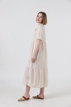 Bir model, Topshow toptan giyim markasının top10241-dress-stone toptan Elbise ürününü sergiliyor.