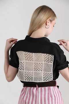 Bir model, Topshow toptan giyim markasının top10319-shirt-with-laced-back-black toptan Crop Top ürününü sergiliyor.