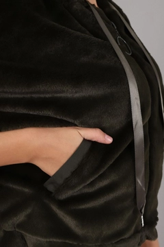 Bir model, Topshow toptan giyim markasının top10368-plush-coat-black toptan Kaban ürününü sergiliyor.