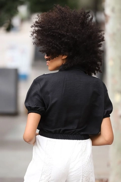 Bir model, Topshow toptan giyim markasının top10411-mesh-shirt-black toptan Crop Top ürününü sergiliyor.