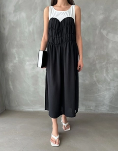 Bir model, Topshow toptan giyim markasının top10804-black-dress toptan Elbise ürününü sergiliyor.