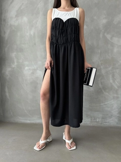 Bir model, Topshow toptan giyim markasının top10804-black-dress toptan Elbise ürününü sergiliyor.