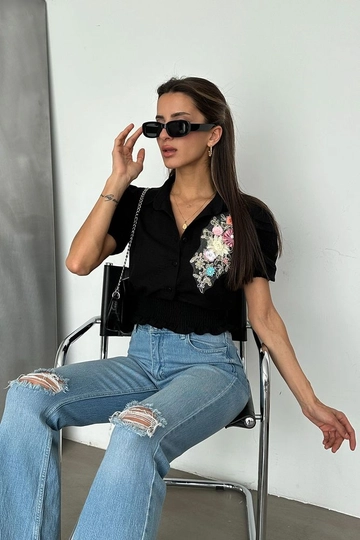 Bir model, Topshow toptan giyim markasının  Siyah D 2651 Göğsü Çiçekli Keten Gömlek
 toptan Gömlek ürününü sergiliyor.