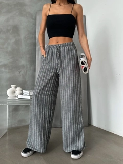 Bir model, Topshow toptan giyim markasının top11140-black-d-2634-striped-linen-trousers toptan Pantolon ürününü sergiliyor.