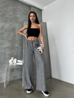 Bir model, Topshow toptan giyim markasının top11140-black-d-2634-striped-linen-trousers toptan Pantolon ürününü sergiliyor.