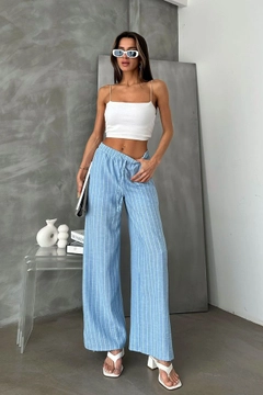 Bir model, Topshow toptan giyim markasının top11141-blue-d-2634-striped-linen-trousers toptan Pantolon ürününü sergiliyor.