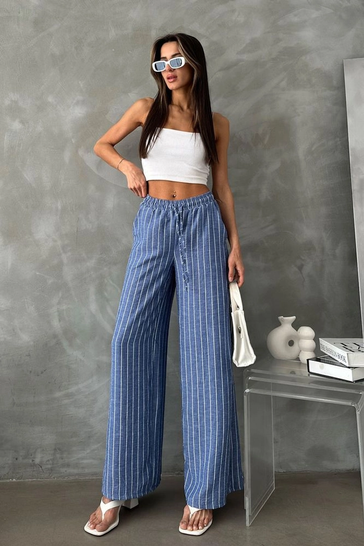 Bir model, Topshow toptan giyim markasının top11144-saks-d-2634-striped-linen-trousers toptan Pantolon ürününü sergiliyor.