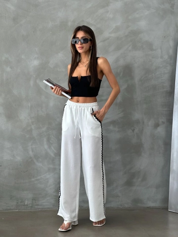 Bir model, Topshow toptan giyim markasının  Sutaşı Detaylı Pantolon - Krem
 toptan Pantolon ürününü sergiliyor.