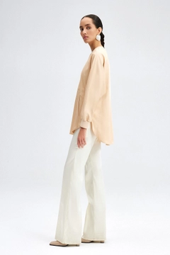 Bir model, Touche Prive toptan giyim markasının tou12236-satin-pocket-detail-tunic-beige toptan Tunik ürününü sergiliyor.