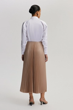 Bir model, Touche Prive toptan giyim markasının tou12910-pleated-skirt-mink toptan Etek ürününü sergiliyor.
