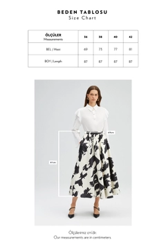 Bir model, Touche Prive toptan giyim markasının TOU11072 - Patterned Satin Skirt - Ecru toptan Etek ürününü sergiliyor.