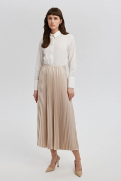Bir model, Touche Prive toptan giyim markasının tou12859-pleated-skirt-beige toptan Etek ürününü sergiliyor.