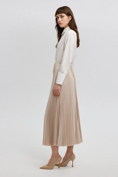 Bir model, Touche Prive toptan giyim markasının tou12859-pleated-skirt-beige toptan Etek ürününü sergiliyor.