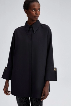 Bir model, Touche Prive toptan giyim markasının tou11671-poplin-shirt-with-widee-cuff-black toptan Gömlek ürününü sergiliyor.