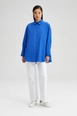 Bir model,  toptan giyim markasının tou12120-relaxed-fit-poplin-shirt-blue toptan  ürününü sergiliyor.