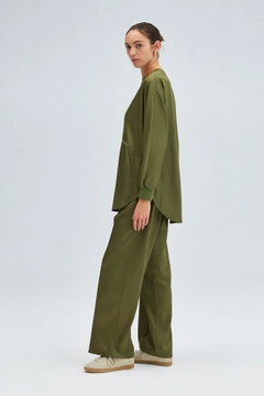 Bir model, Touche Prive toptan giyim markasının tou12219-satin-pocket-detail-tunic-khaki toptan Tunik ürününü sergiliyor.