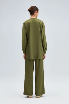 Bir model, Touche Prive toptan giyim markasının tou12219-satin-pocket-detail-tunic-khaki toptan Tunik ürününü sergiliyor.