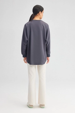 Bir model, Touche Prive toptan giyim markasının tou12220-satin-pocket-detail-tunic-grey toptan Tunik ürününü sergiliyor.