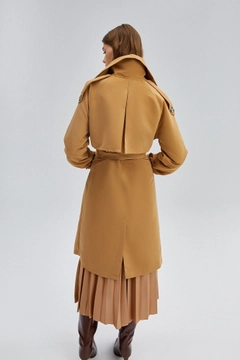 Bir model, Touche Prive toptan giyim markasının 33917 - Double Breasted Trenchcoat toptan Trençkot ürününü sergiliyor.