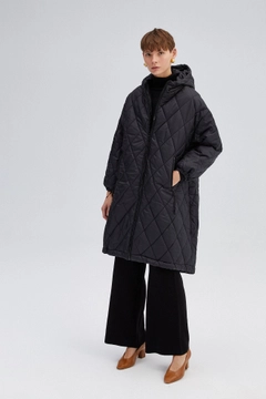 Un mannequin de vêtements en gros porte 33924 - Quilted Long Coat, Manteau en gros de Touche Prive en provenance de Turquie