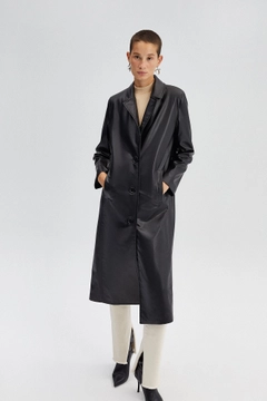 Bir model, Touche Prive toptan giyim markasının 34565 - Faux Leather Trenchcoat toptan Trençkot ürününü sergiliyor.