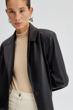 Bir model, Touche Prive toptan giyim markasının 34565 - Faux Leather Trenchcoat toptan Trençkot ürününü sergiliyor.