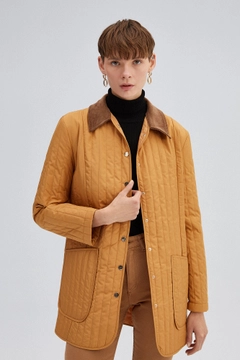 Un mannequin de vêtements en gros porte 34668 - Quilted Coat, Manteau en gros de Touche Prive en provenance de Turquie