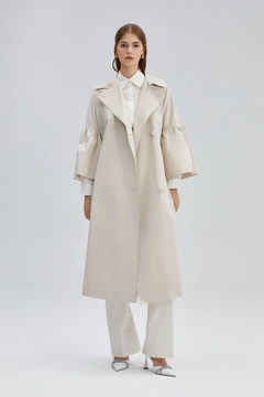 Bir model, Touche Prive toptan giyim markasının 34699 - Trenchcoat With Pearl Belt toptan Trençkot ürününü sergiliyor.