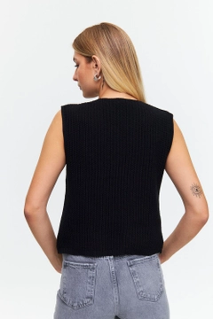 Bir model, Tuba Butik toptan giyim markasının tbu12487-lace-detailed-crew-neck-women's-knitwear-vest-black toptan Yelek ürününü sergiliyor.