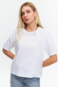 Bir model, Tuba Butik toptan giyim markasının tbu12506-crew-neck-basic-short-sleeve-women's-white toptan Tişört ürününü sergiliyor.