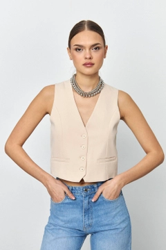 Bir model, Tuba Butik toptan giyim markasının tbu12169-straight-cut-women's-vest-beige toptan Yelek ürününü sergiliyor.
