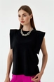 Bir model,  toptan giyim markasının tbu10921-crew-neck-zero-sleeve-basic-women's-blouse-black toptan  ürününü sergiliyor.