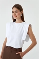 Bir model,  toptan giyim markasının tbu10920-crew-neck-zero-sleeve-basic-women's-white toptan  ürününü sergiliyor.