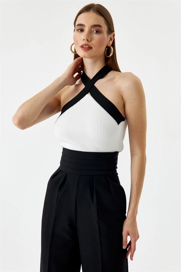 Bir model, Tuba Butik toptan giyim markasının  Çapraz Askılı Triko Kadın Bluz - Beyaz
 toptan Bluz ürününü sergiliyor.