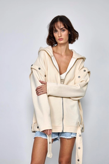 Bir model, Tuba Butik toptan giyim markasının  Kolları Ayrılabilir Çıtçıt Detaylı Kadın Sweatshirt - Krem
 toptan Sweatshirt ürününü sergiliyor.