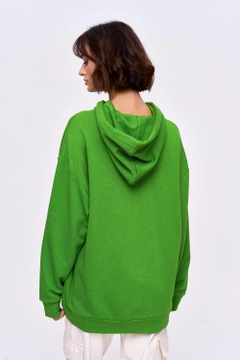 Bir model, Tuba Butik toptan giyim markasının 36188 - Sweatshirt - Green toptan Hoodie ürününü sergiliyor.