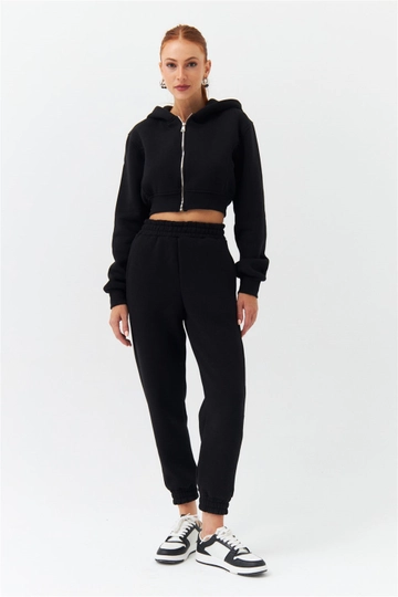 Bir model, Tuba Butik toptan giyim markasının  Eşofman Takımı - Siyah
 toptan Eşofman Takımı ürününü sergiliyor.