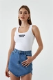 Bir model,  toptan giyim markasının tbu10890-corded-basic-embroidery-women's-athlete-white toptan  ürününü sergiliyor.