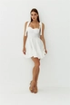 Bir model,  toptan giyim markasının tbu11332-tie-bust-cup-mini-dress-white toptan  ürününü sergiliyor.