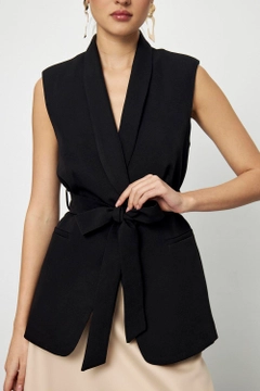 Bir model, Tuba Butik toptan giyim markasının tbu11966-belted-tuxedo-collar-women's-vest-black toptan Yelek ürününü sergiliyor.
