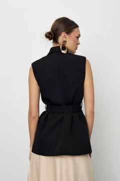 Ένα μοντέλο χονδρικής πώλησης ρούχων φοράει tbu11966-belted-tuxedo-collar-women's-vest-black, τούρκικο Αμάνικο μπλουζάκι χονδρικής πώλησης από Tuba Butik